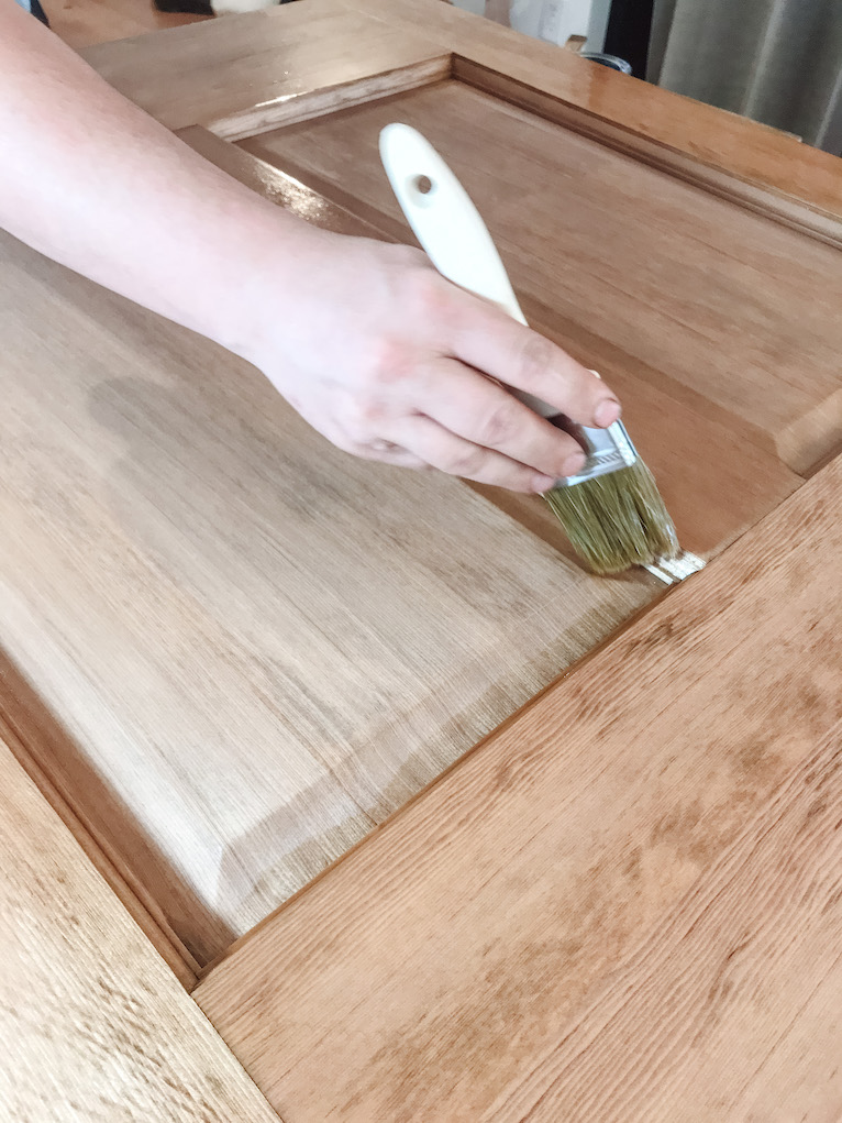 brushing sealer into nook of wood door