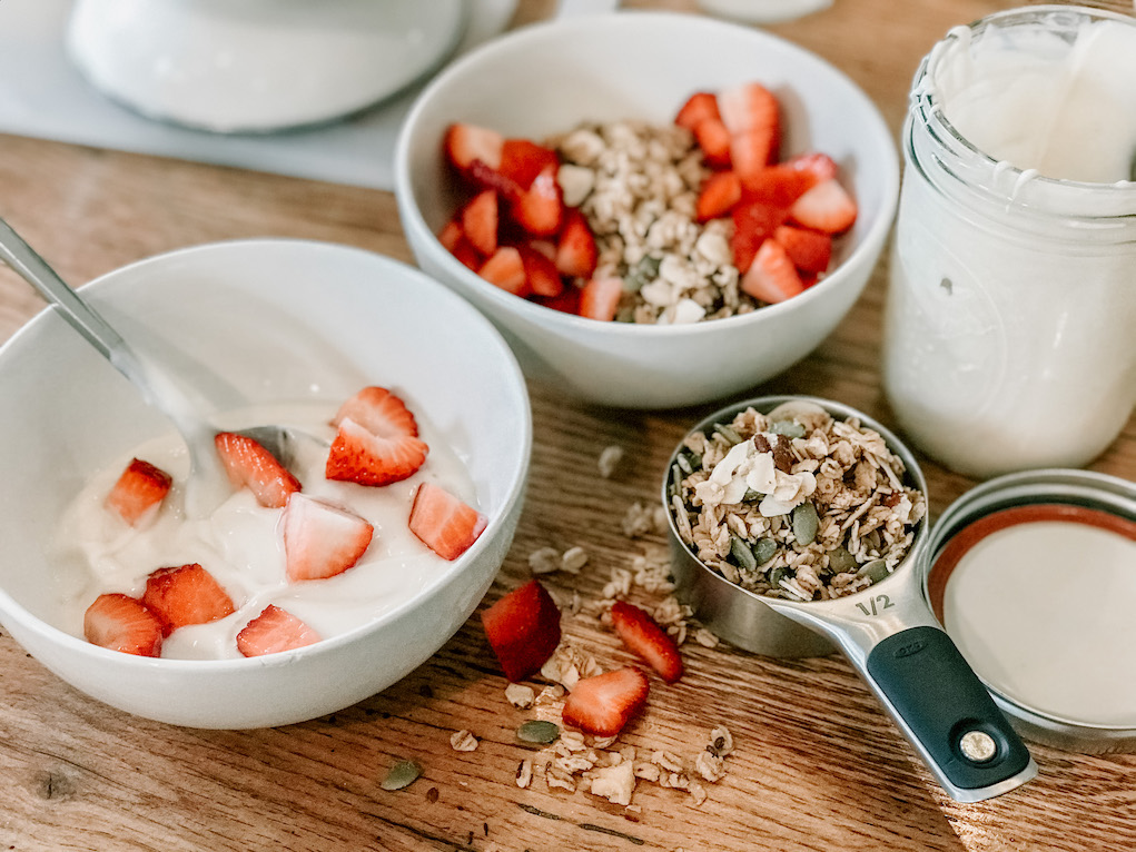 breakfast granola with homemade yogurt and fresh strawberries in a bowl